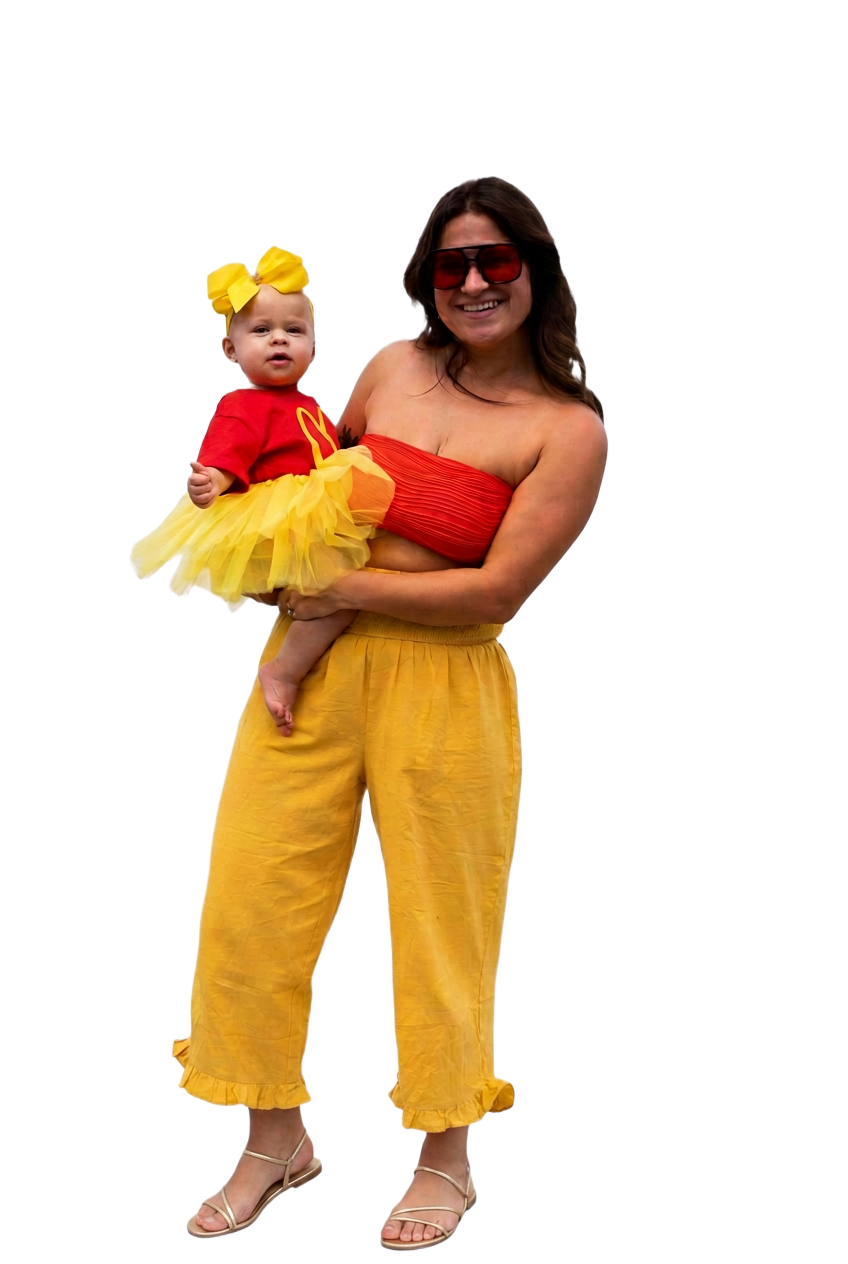 By Design Events founder holding her young daughter in coordinated red and gold outfits